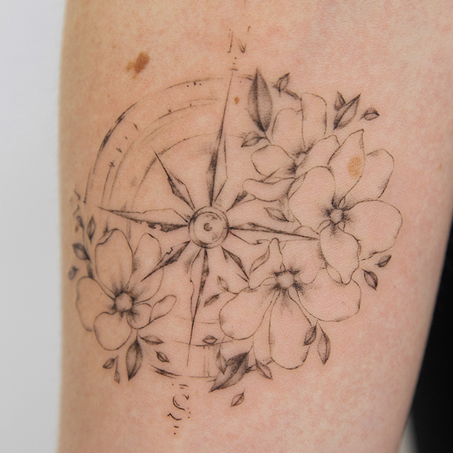 forearm fineline flower tattoo with a compass from smasli ink an female tattoo artist working in salzburg austria