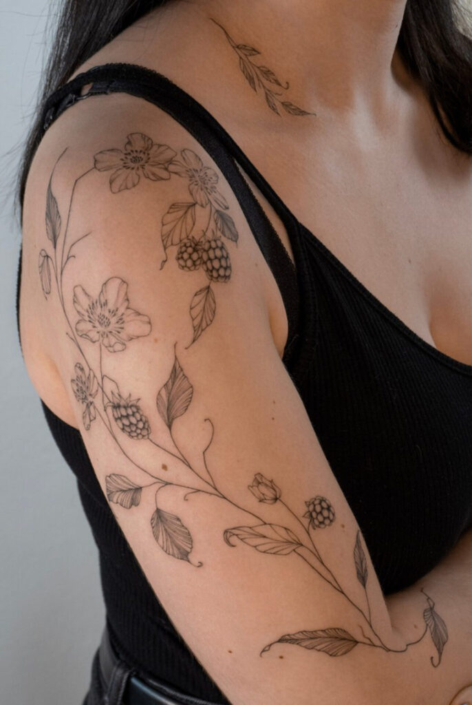 upper arm fineline flower tattoo with berries from smasli ink an female tattoo artist working in salzburg austria