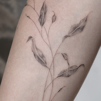 forearm fineline flower tattoo with leaves from smasli ink an female tattoo artist working in salzburg austria