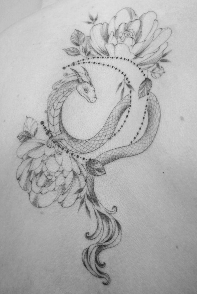 back fineline flower tattoo with dragon from smasli ink an female tattoo artist working in salzburg austria
