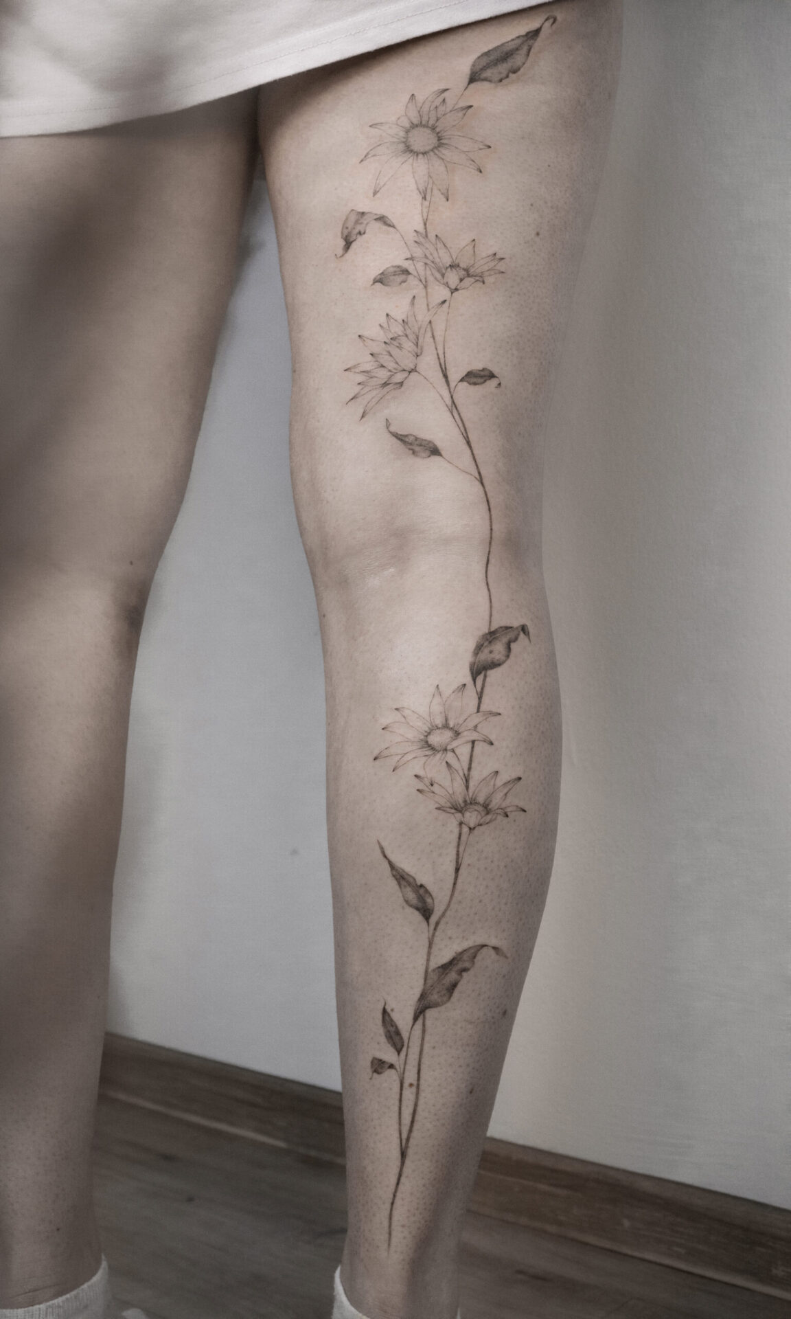 fineline flower tattoo whole leg from smasli ink an female tattoo artist working in salzburg austria