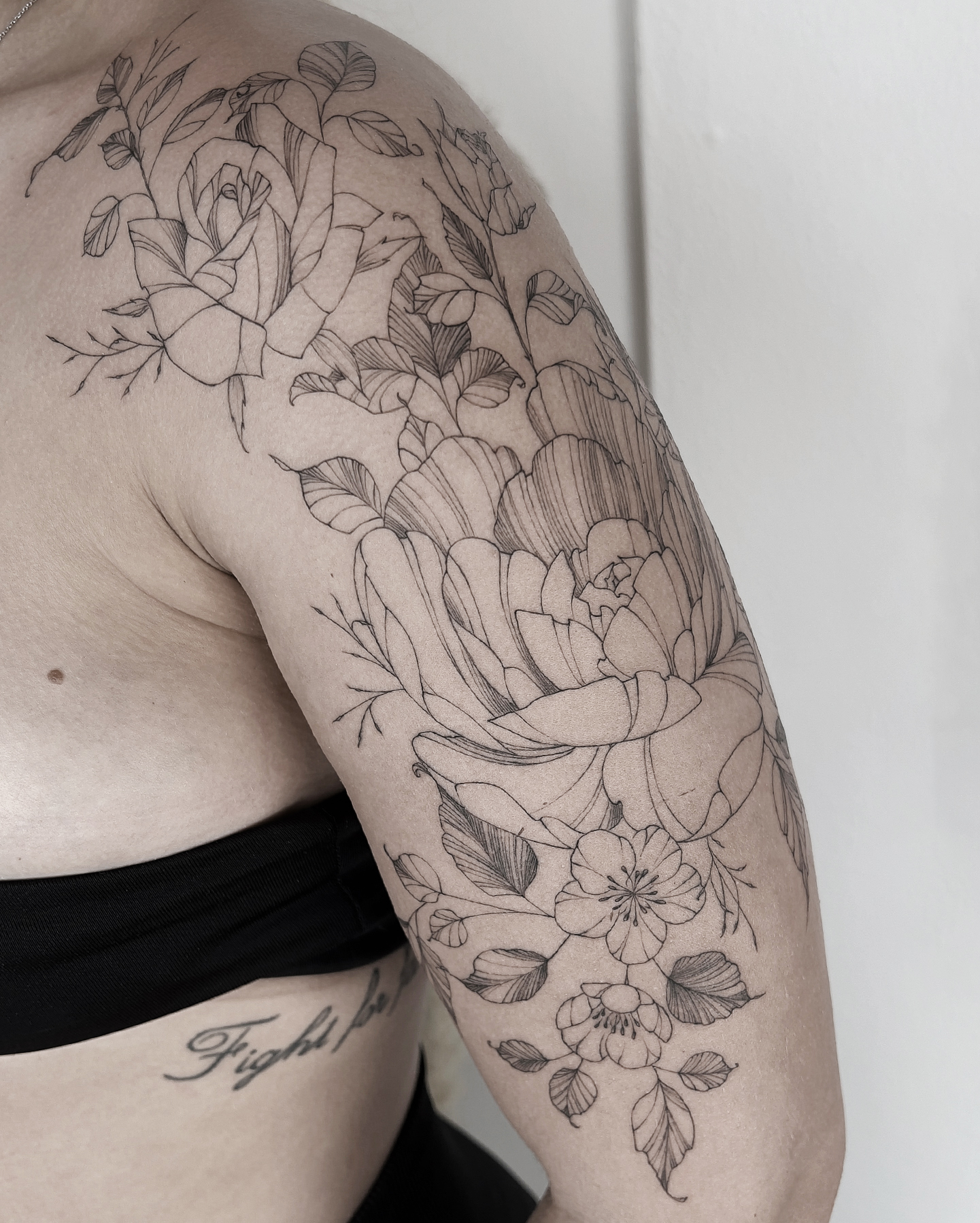 upper arm fineline flower tattoo with peony and rose from smasli ink an female tattoo artist working in salzburg austria