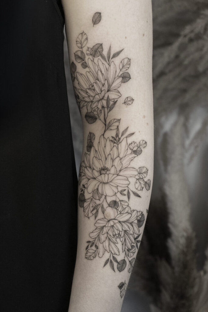 fineline flower sleeve tattoo with magnolia from smasli ink an female tattoo artist working in salzburg austria
