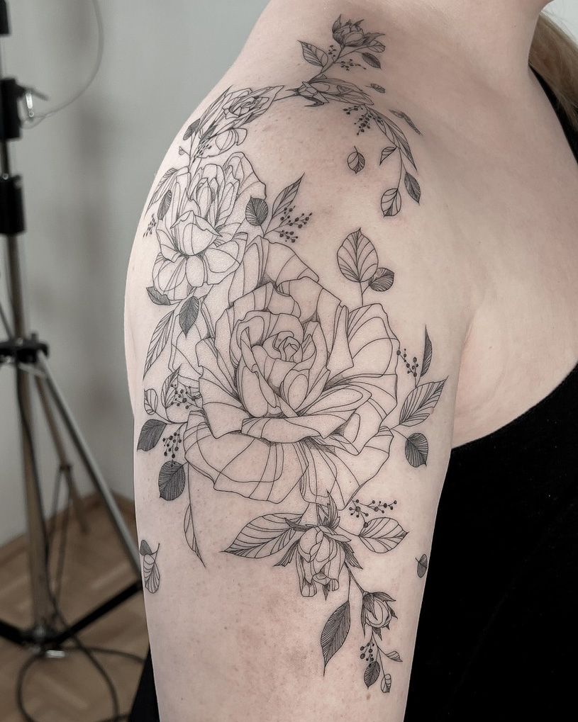 fineline flower tattoo on upper arm with roses from smasli ink an female tattoo artist working in salzburg austria