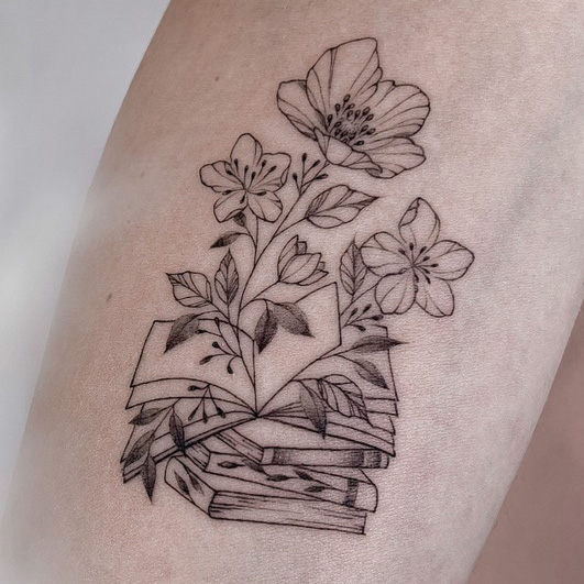 fineline flower tattoo on forearm with a book from smasli ink an female tattoo artist working in salzburg austria