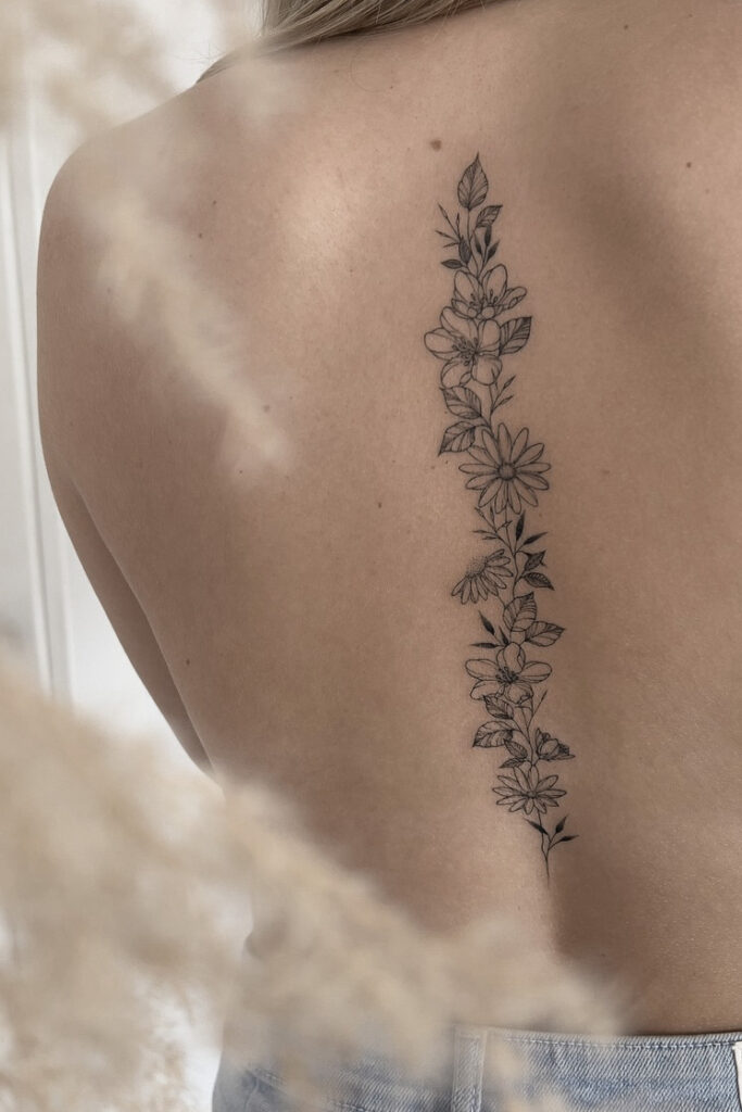 fineline flower tattoo on bakc from smasli ink an female tattoo artist working in salzburg austria