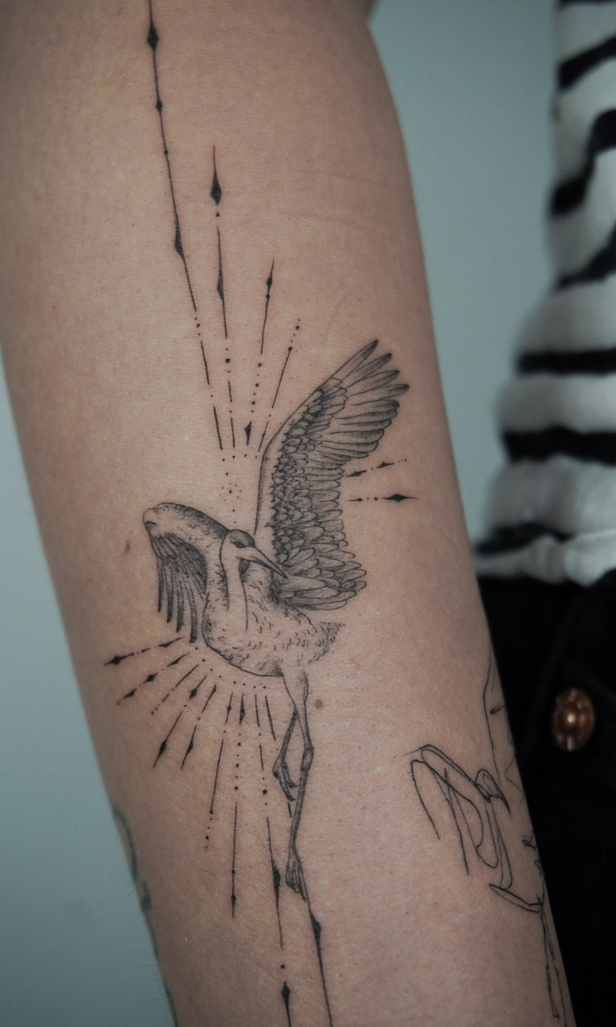 fineline flower tattoo on forearm with bird from smasli ink an female tattoo artist working in salzburg austria