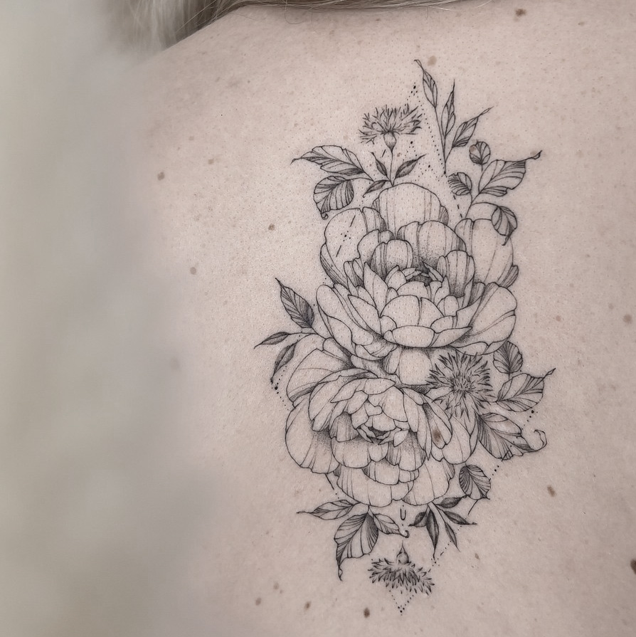 fineline flower back tattoo with peony from smasli ink an female tattoo artist working in salzburg austria